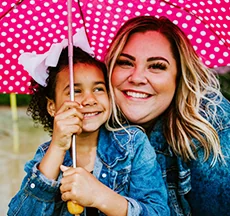 Woman and daughter under umbrella