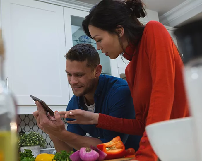 couple using digital tablet in kitchen at home