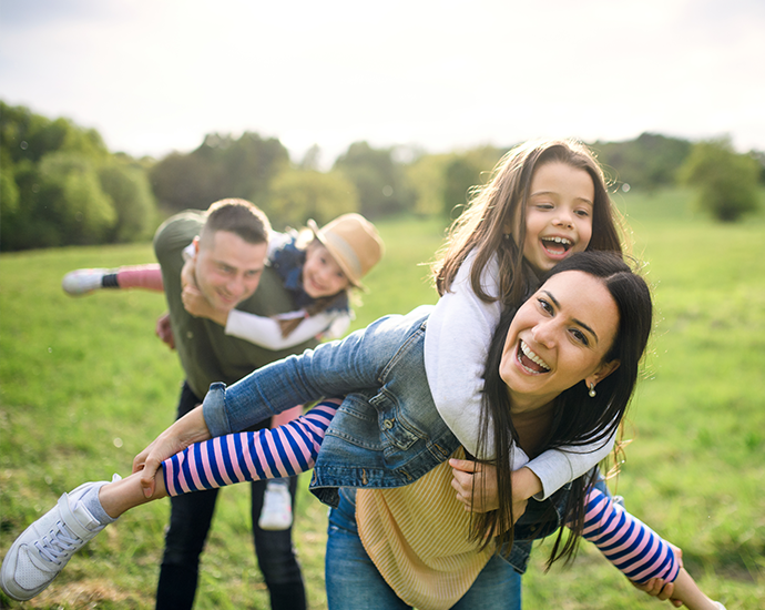 Young Family Piggyback Fun Outdoors